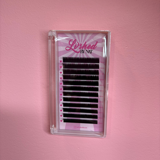 False eyelashes in a clear plastic case on a pink background